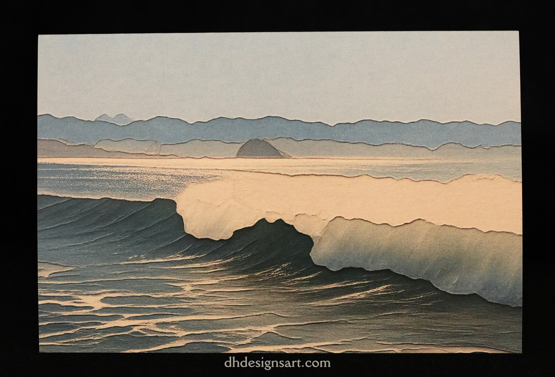 A notecard depicting a wave crashing on a Cayucos beach with layered fog bank and Morro Rock in the background, presented on a black background with a watermark at the bottom.