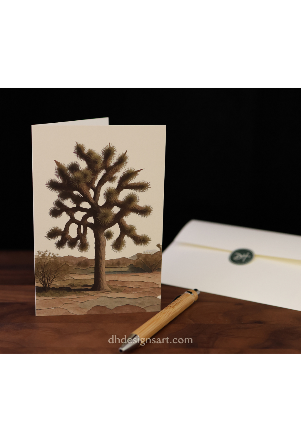 Greeting card with a Joshua tree design on a wooden desk. Blank noteccard by dhdesignsart.com.