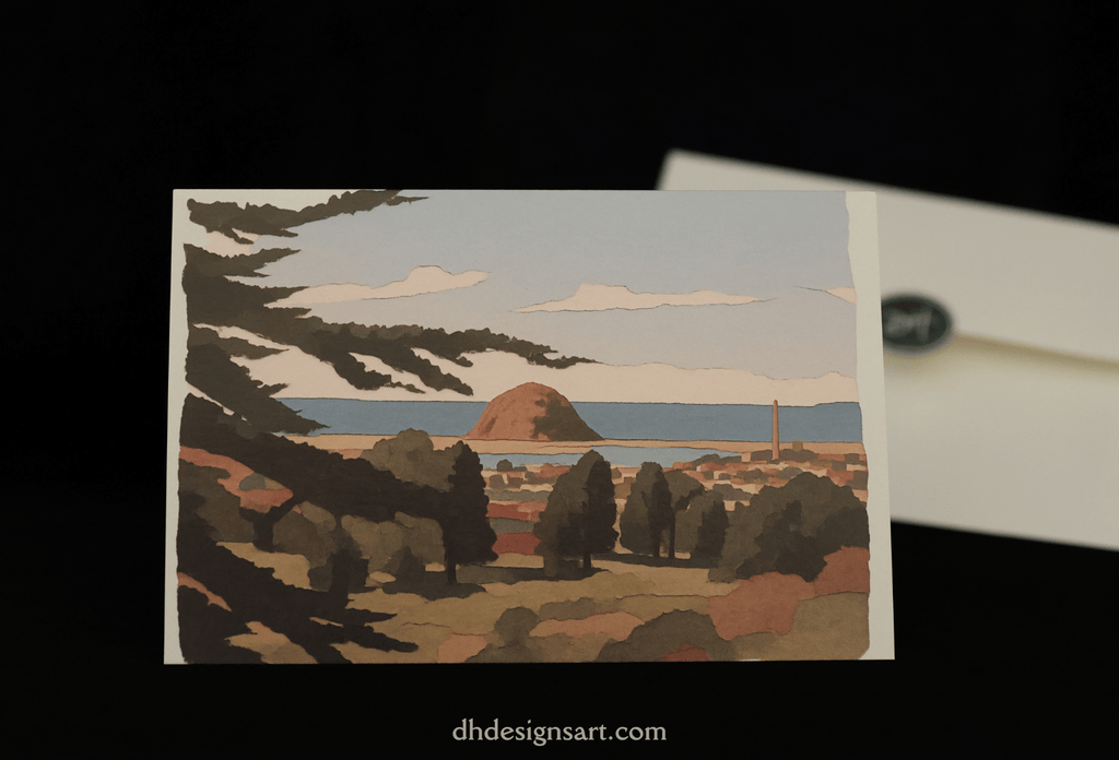 A notecard featuring a stylized landscape illustration of Morro Bay, CA, with trees, Morro Rock, the ocean, and sky, displayed against a black background with part of a white envelope visible behind it.
